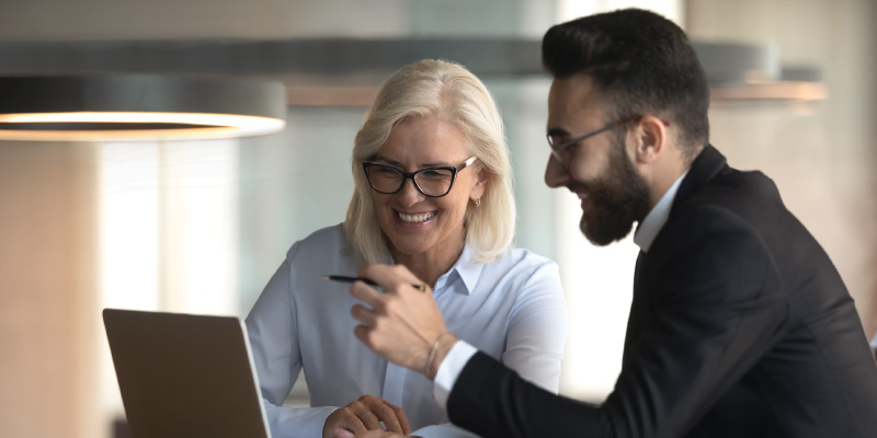 A woman and a man are having a business meeting looking at a laptop screen