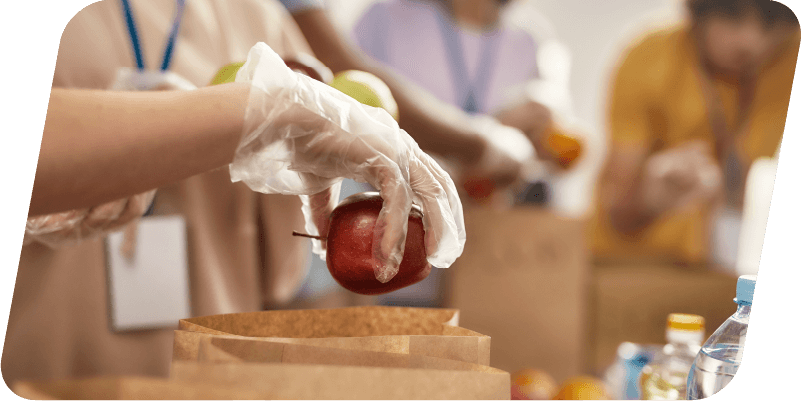 People packing brown paper bags full of meals